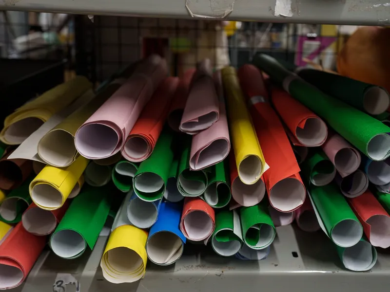 Rolls of brightly coloured card on a shelf