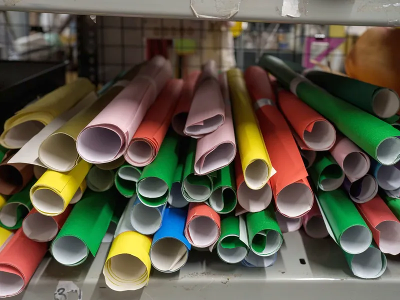 Rolls of brightly coloured card on a shelf